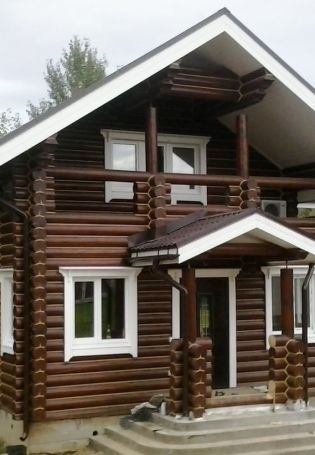 Коричневый деревянный дом с белыми окнами