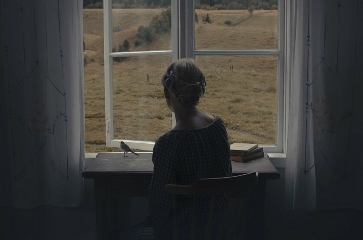 Девочка сидит у окна
