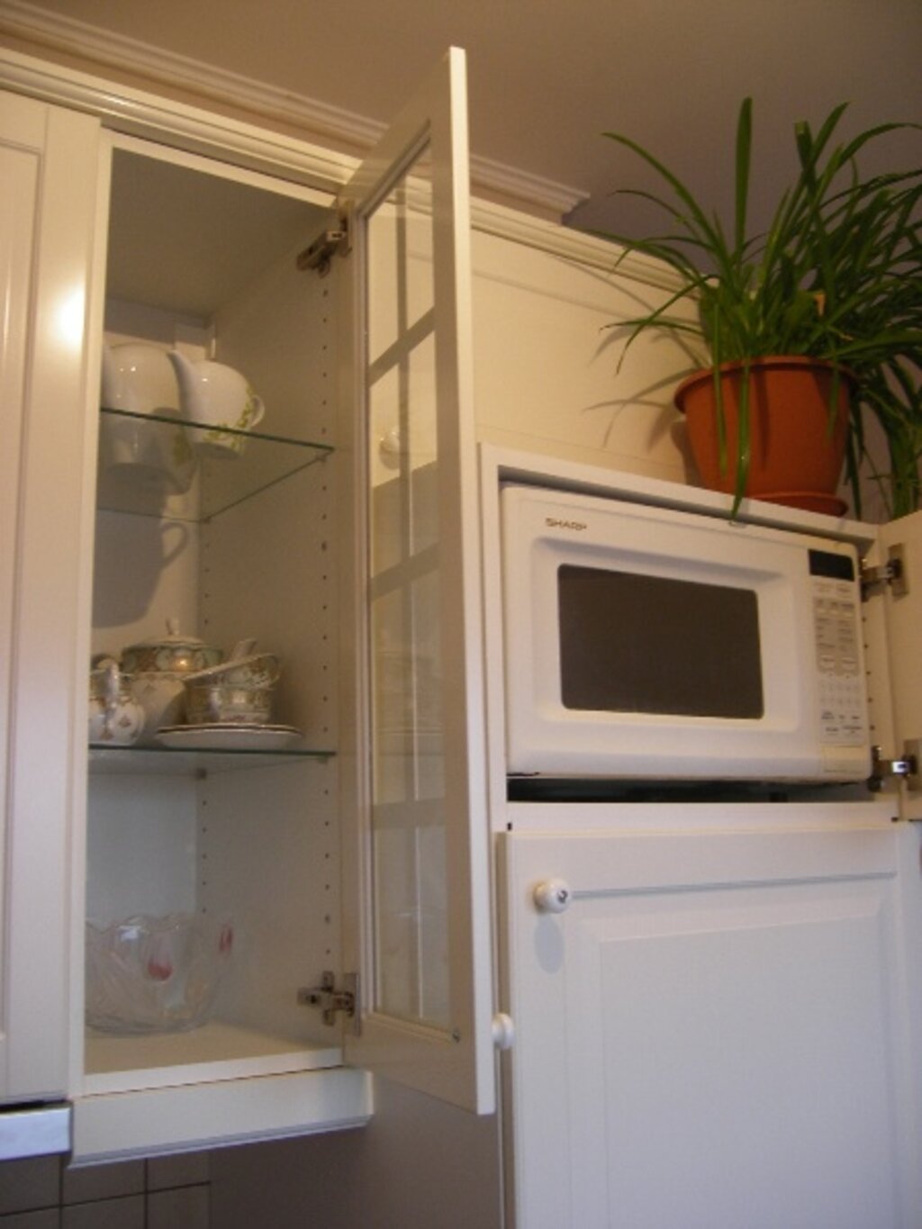 Можно ли ставить микроволновку на холодильник сверху. Микроволновая печь на холодильнике. Микроволновку на холодильник. Микроволновка на кухне. Микроволновка над холодильником.